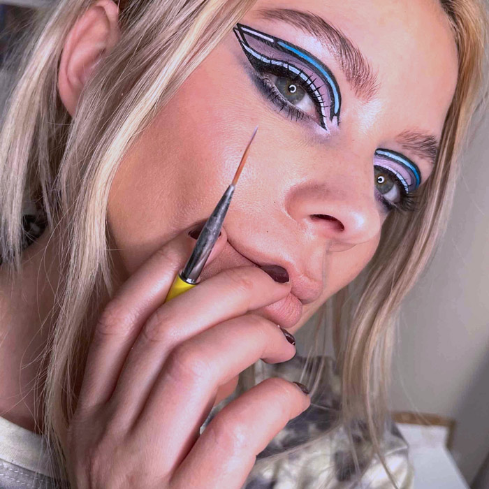 liza kondrevich with a brush and graphic eyeliner
